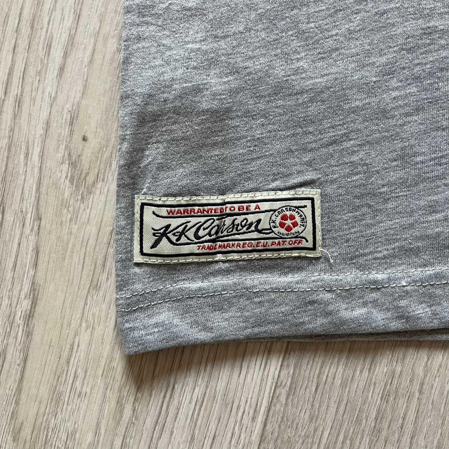 Gray fabric with a K. K. Carson label on a wooden surface