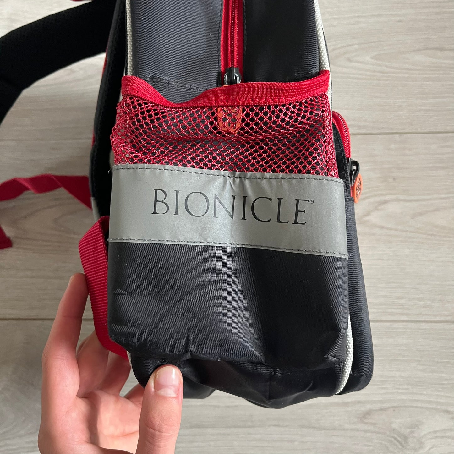 Lego Bionicle 2010 Glatorian Gresh Backpack made by Class Investment in 2010, featuring a front pocket with an embroidered Glatorian Ackar figure and text. The top pocket includes both Bionicle and LEGO logos, along with custom rubber zipper pulls. Finished with two side bottle pockets and additional Bionicle logo details, making it a great rare collectible for fans of the series.