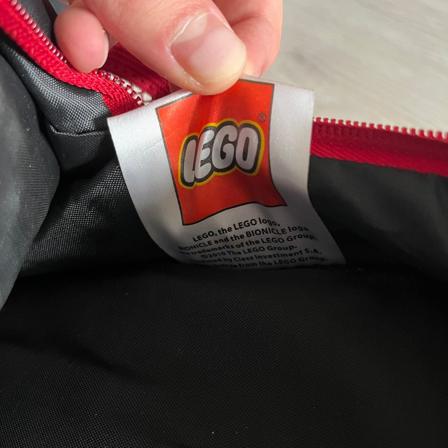 Lego Bionicle 2010 Glatorian Gresh Backpack made by Class Investment in 2010, featuring a front pocket with an embroidered Glatorian Ackar figure and text. The top pocket includes both Bionicle and LEGO logos, along with custom rubber zipper pulls. Finished with two side bottle pockets and additional Bionicle logo details, making it a great rare collectible for fans of the series.