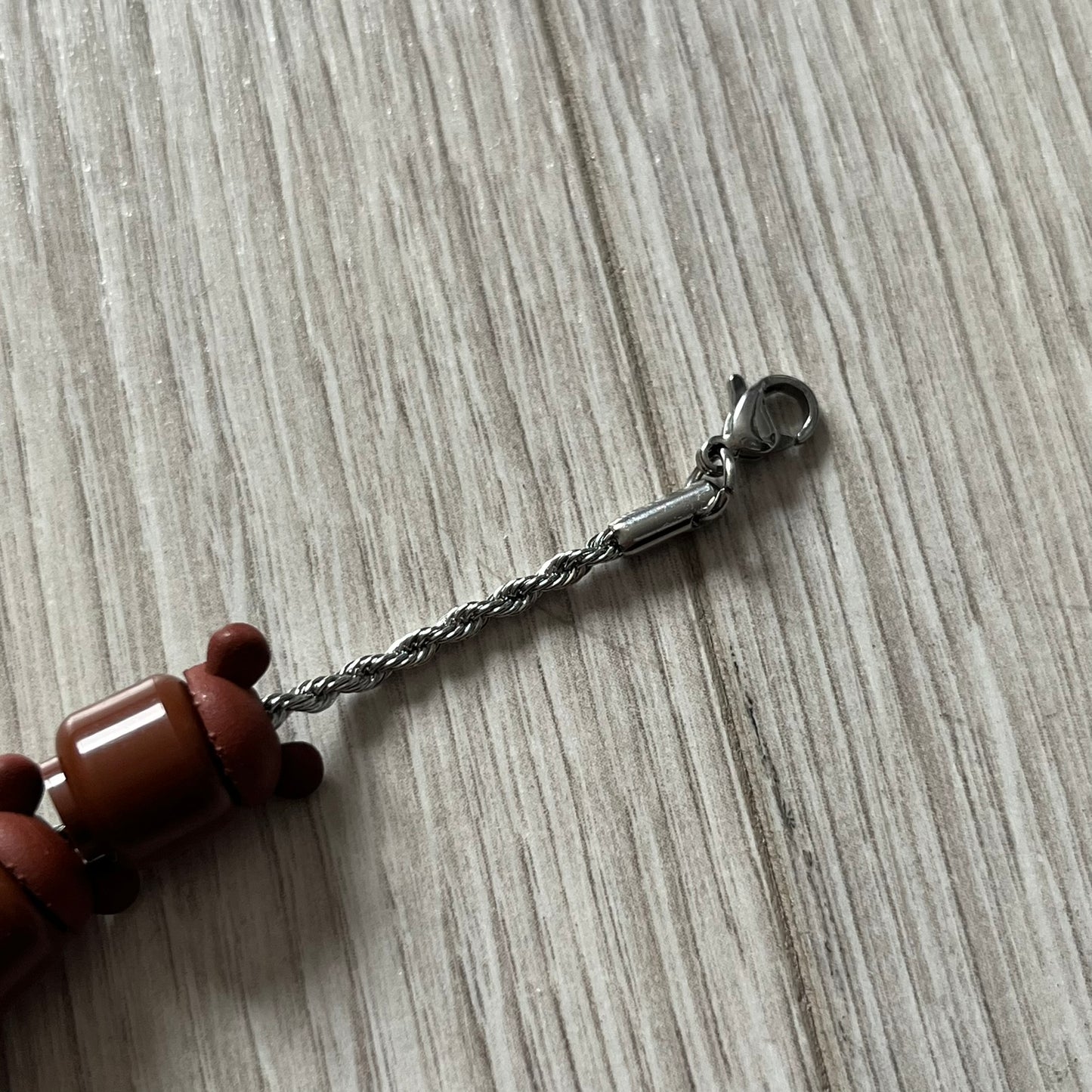 Lego Graduation Brick Bracelet featuring ten brown Lego bear heads from Kanye West’s Graduation era, set on a thin silver bracelet. The heads are standard Lego size and the piece comes in a custom-designed display box. Made by TheCanvasDon.