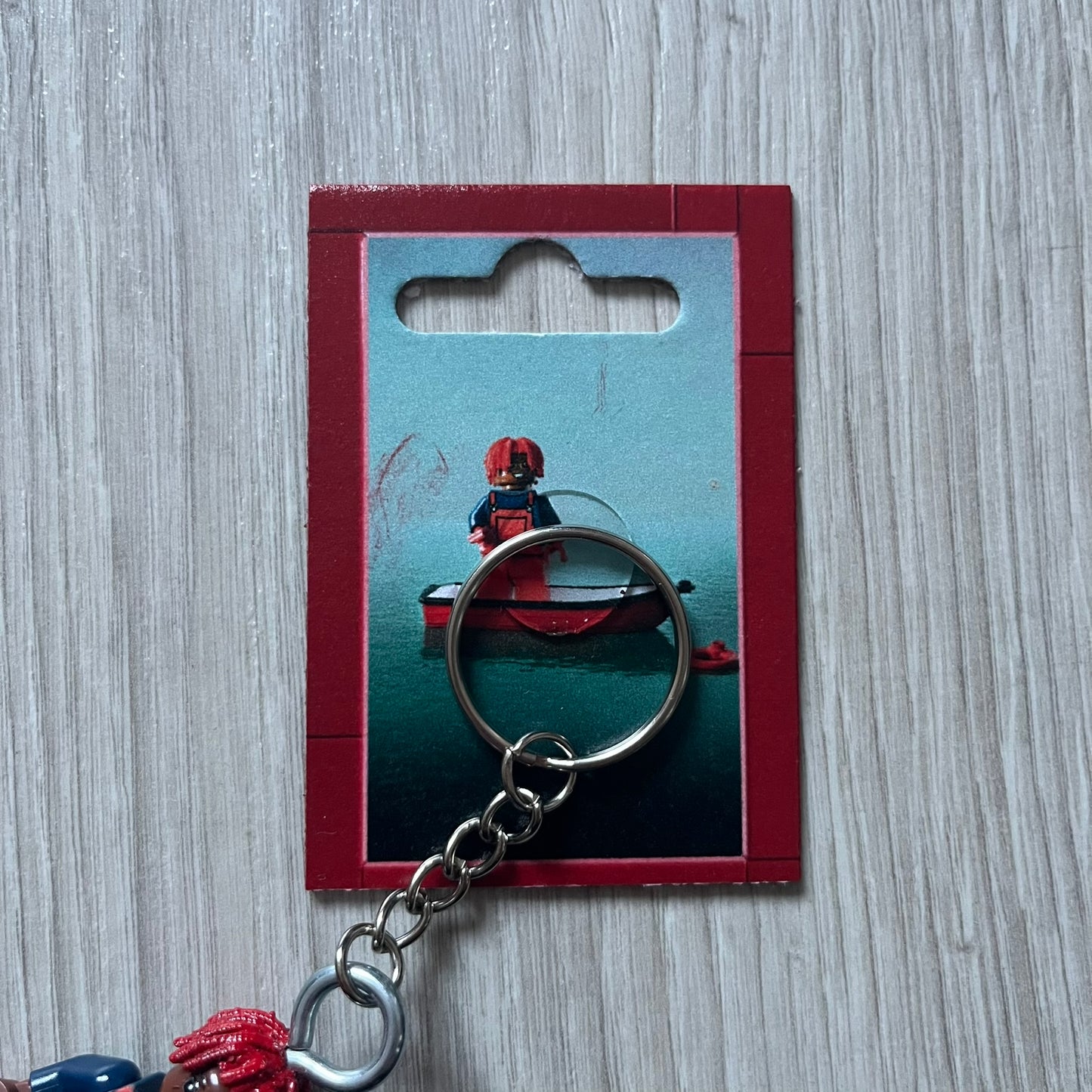 Lego Lil Yachty 'Lil Block' keychain featuring a custom Lego figure of Lil Yachty with red overalls and 3d red dreads. The figure is attached to a Lego-style recreation of the 2016 'Lil Boat' album cover, reimagined in brick graphics. A playful and creative collectible that merges music culture with fan-made Lego artistry, made by TheCanvasDon.