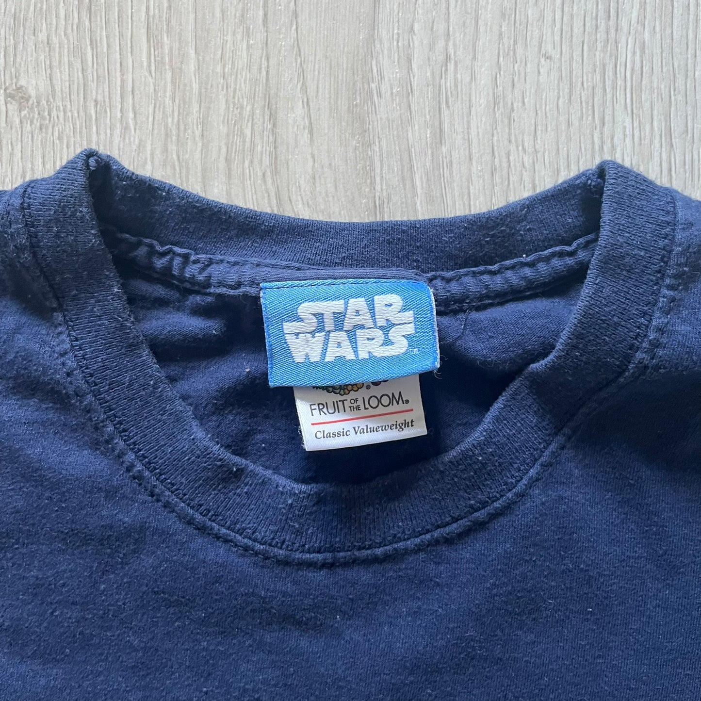 Vintage 2007 Lego Star Wars tee featuring Luke Skywalker with a lightsaber and the quote “I am a Jedi like my father before me.” Small Lego Star Wars logo sits underneath the graphic. Printed on a classic navy Fruit of the Loom blank perfect for collectors and SW fans.