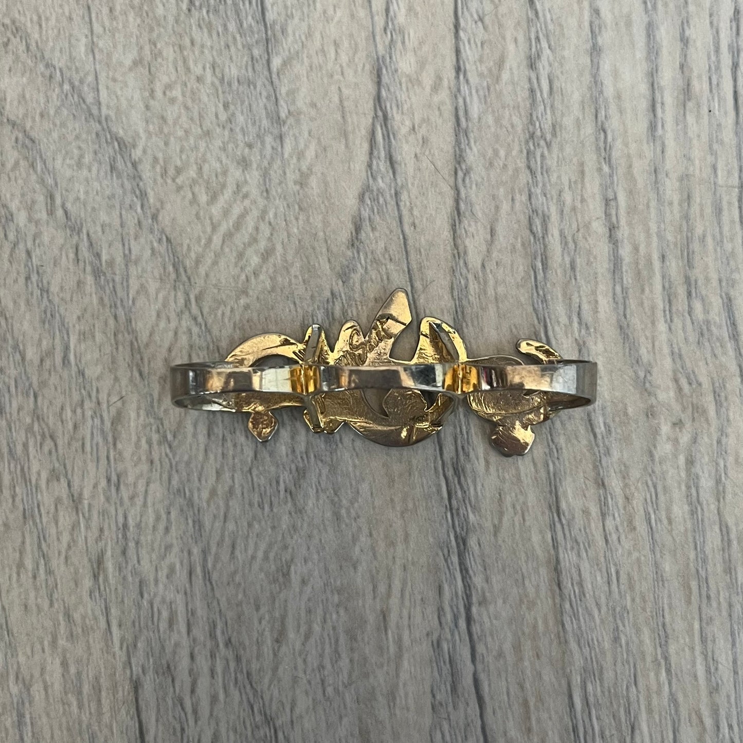 Melody Ehsani x Jeremy Scott 2013 Arabic Three Finger Ring is a gold-tone three-finger ring from the 2013 Fearless collection by Melody Ehsani and Jeremy Scott. The ring features the name “Jeremy” written in Arabic script across the three connected bands. Released in 2013, the piece originally retailed for $100.