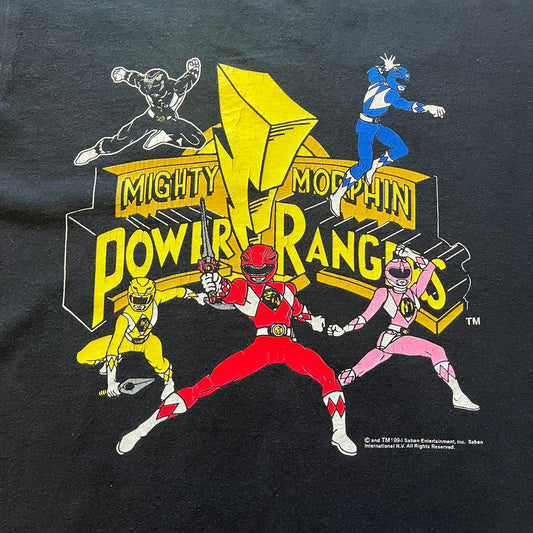 1994 Power Rangers tee with striking full-team graphic, officially licensed by Saban Entertainment. Crafted on a Delta USA-made blank with single stitch finish for authentic vintage feel. Perfect for fans and collectors of classic ‘90s TV.