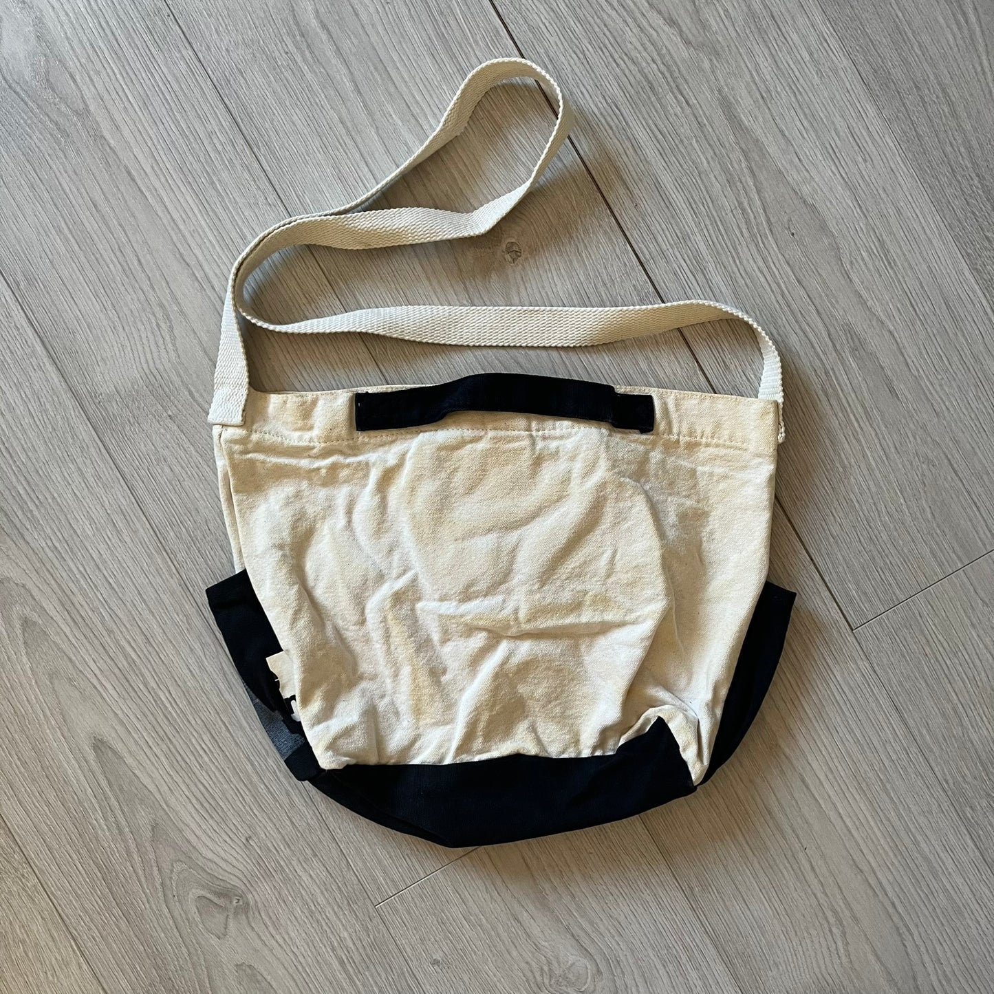 Beige and black bag on a wooden floor