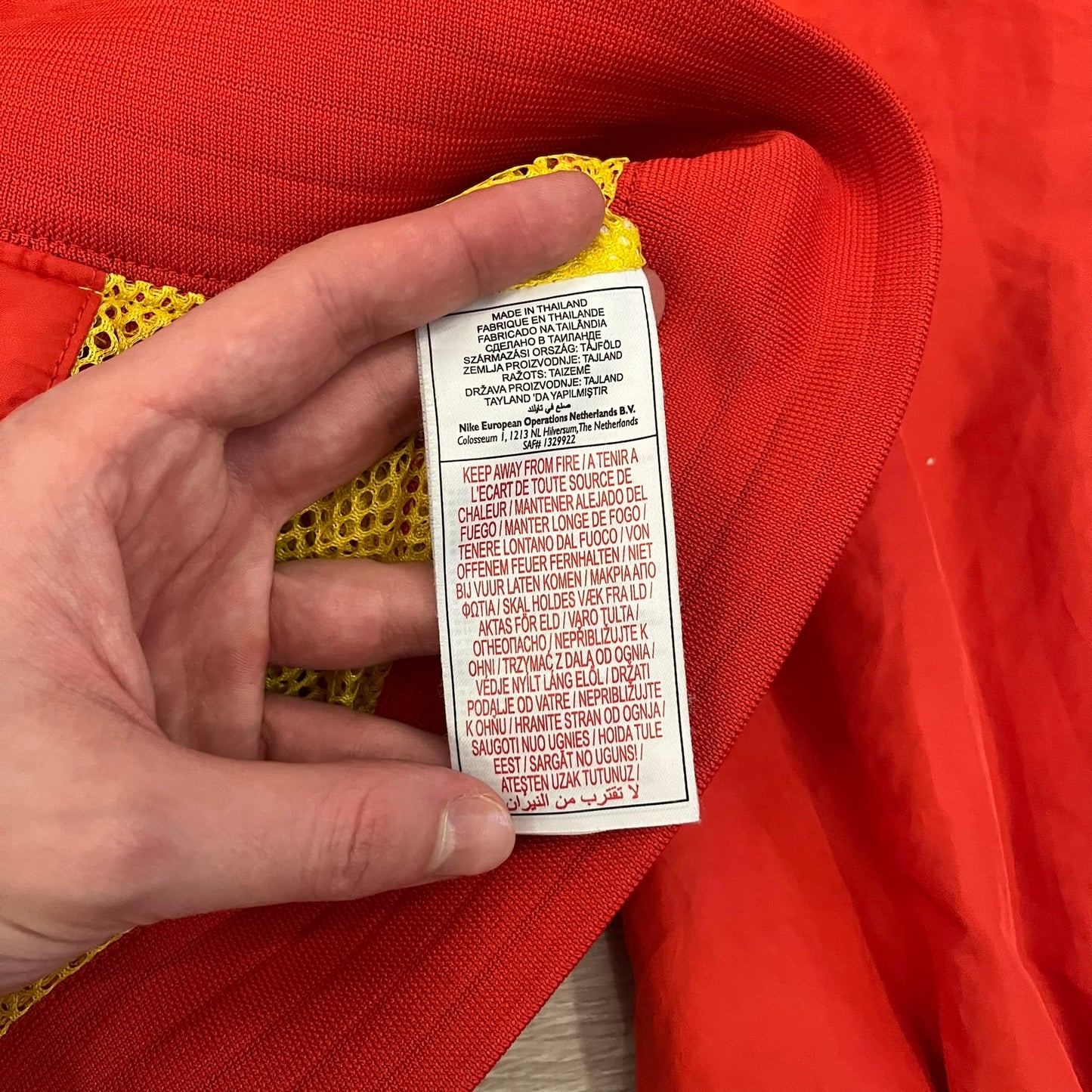 Nike China Olympics Split Windbreaker from 2008, crafted in red with a yellow hood representing China colors. This innovative jacket can be zipped apart on both sides and merged with other compatible models. This jacket doesn't have typical flags in the pockets.