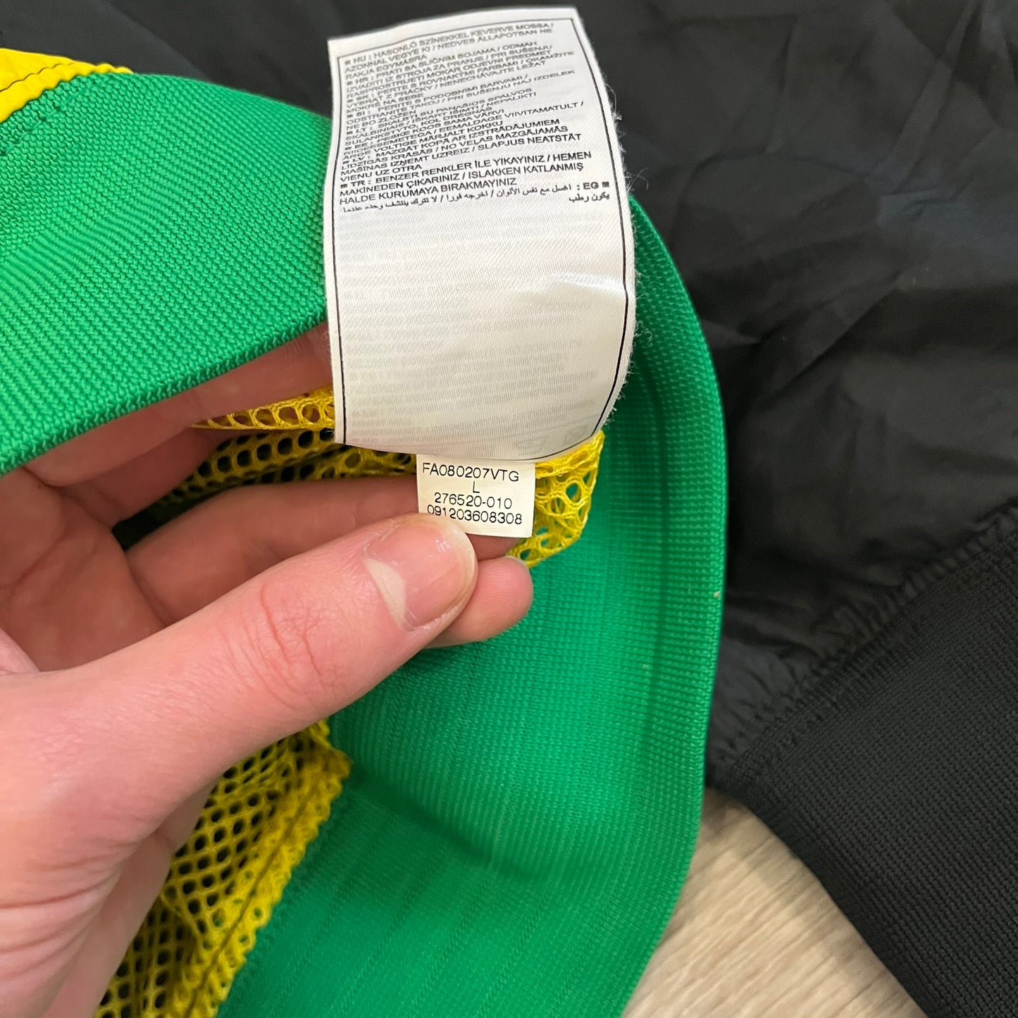 Nike Jamaica Olympics 2008 Split Windbreaker designed by Jarrett Reynolds. Features a black base with a yellow cross on the front inspired by the Jamaican flag. Green bottom hem and details. Dual side zippers allow the jacket to split in half and be combined with other pieces from the collection, with a small Jamaica flags detail inside the pocket.