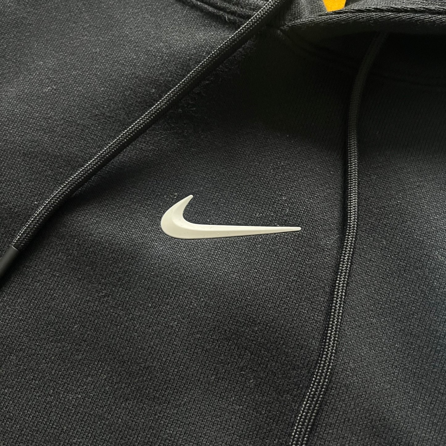 Nike x Nocta Fleece CS Hoodie in Black combines Drake’s refined streetwear vision with Nike’s premium craftsmanship. Made from an ultra-soft fleece blend, it features reflective piping, a silicone Swoosh logo and discreet NOCTA branding. With an adjustable hood, kangaroo pocket, and hidden zip pocket, this piece balances luxury comfort and technical precision.