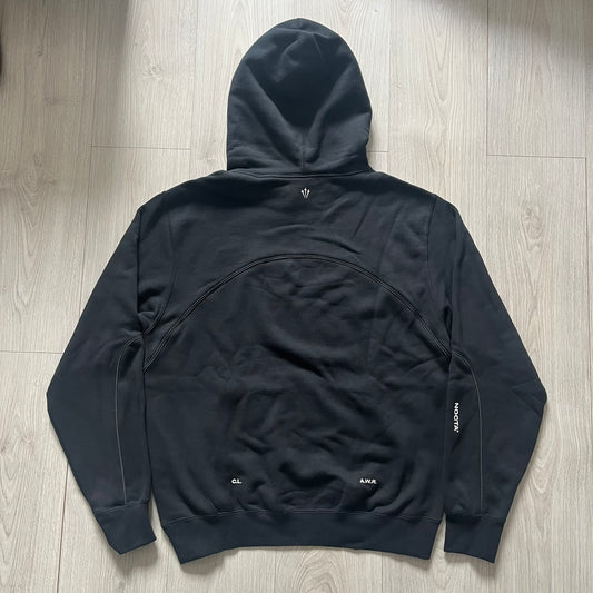 Nike x Nocta Fleece CS Hoodie in Black combines Drake’s refined streetwear vision with Nike’s premium craftsmanship. Made from an ultra-soft fleece blend, it features reflective piping, a silicone Swoosh logo and discreet NOCTA branding. With an adjustable hood, kangaroo pocket, and hidden zip pocket, this piece balances luxury comfort and technical precision.