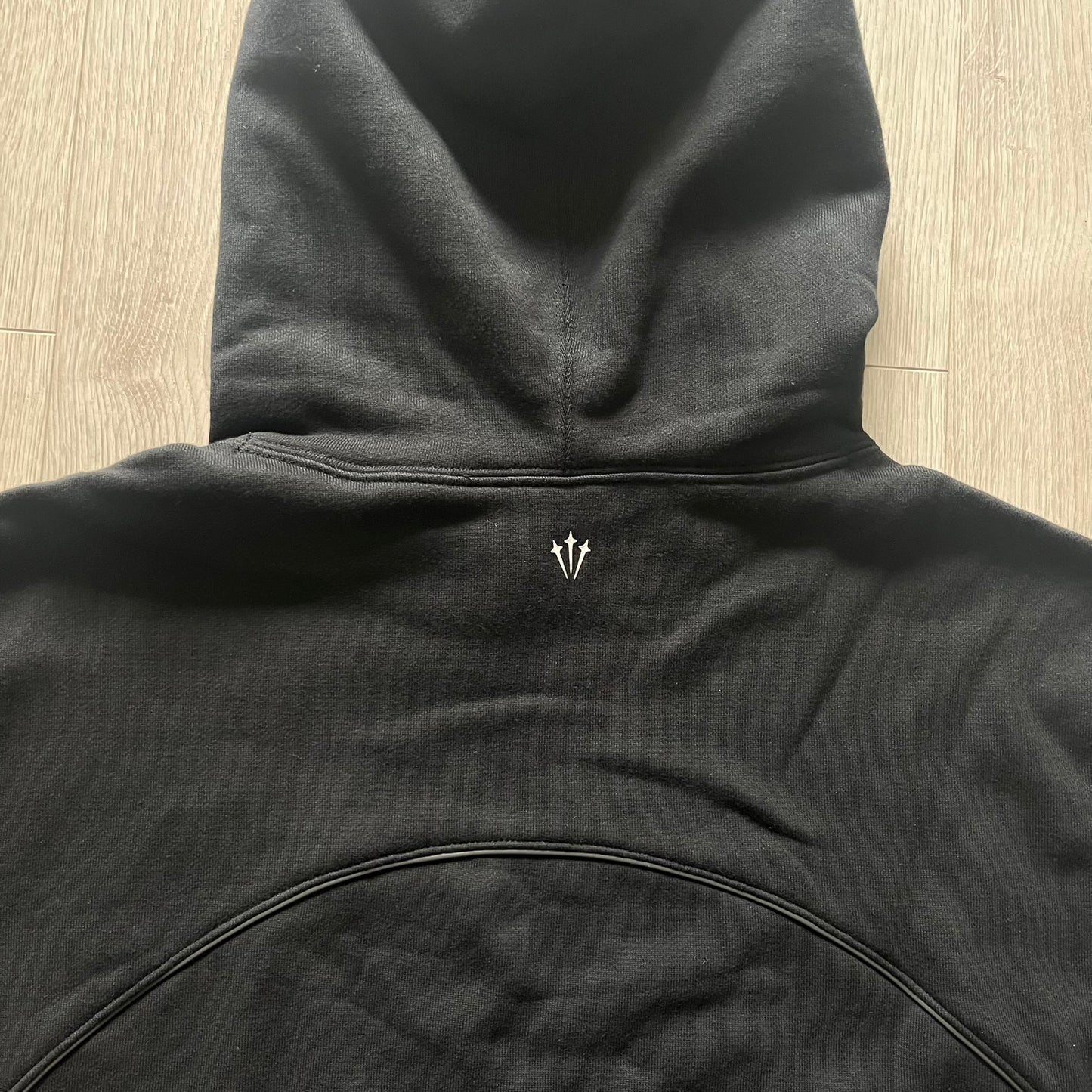 Nike x Nocta Fleece CS Hoodie in Black combines Drake’s refined streetwear vision with Nike’s premium craftsmanship. Made from an ultra-soft fleece blend, it features reflective piping, a silicone Swoosh logo and discreet NOCTA branding. With an adjustable hood, kangaroo pocket, and hidden zip pocket, this piece balances luxury comfort and technical precision.
