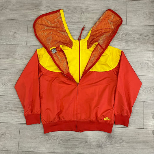 Nike Spain Olympics 2008 Split Windbreaker designed by Jarrett Reynolds. Features a red and yellow base with Spain Coat of arms and Nike black embroidered logo on the front. Dual zippers allow the jacket to be split in half and combined with other pieces from the collection, with a subtle Spain flags inside the pocket.