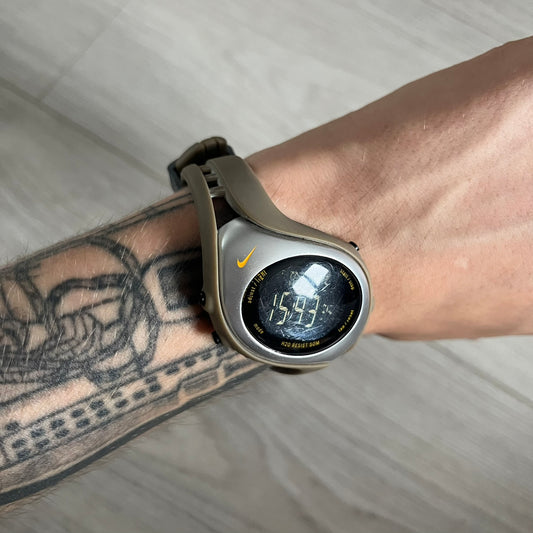 Digital watch on a wrist with a tattooed arm, on a neutral background