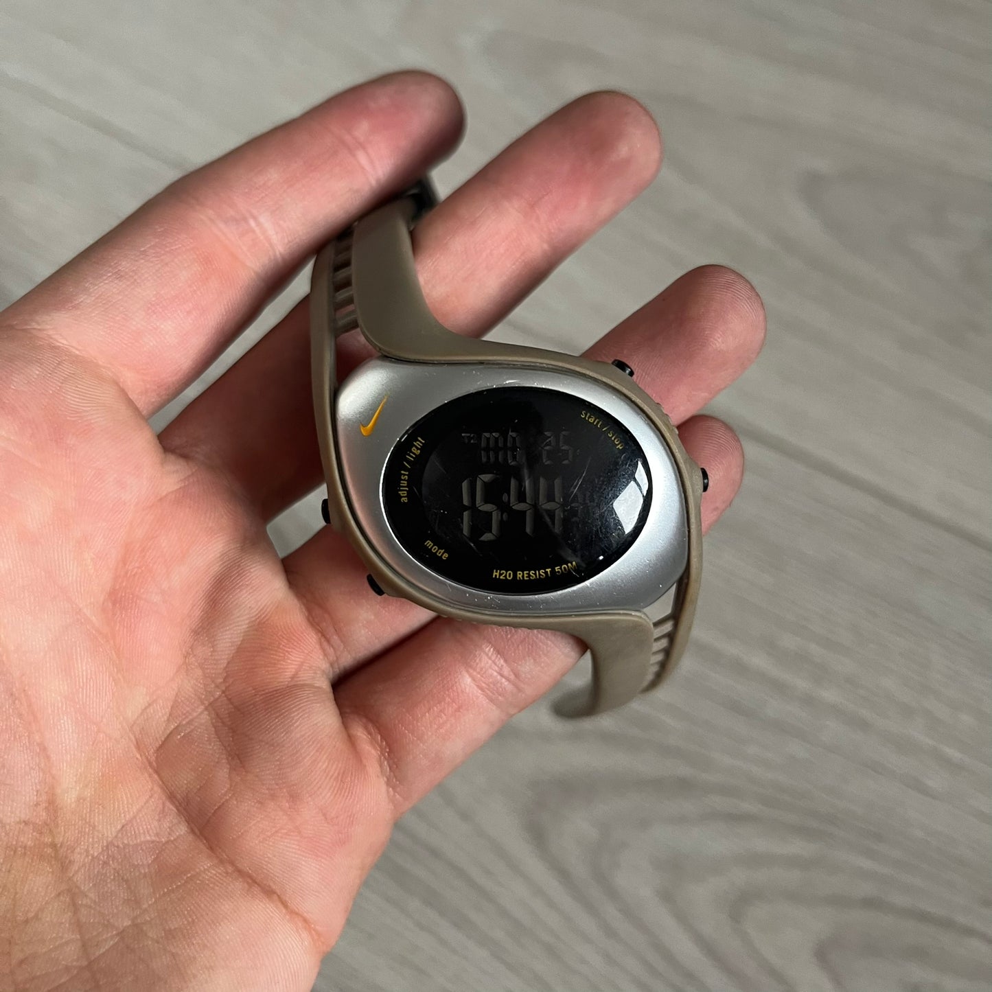 Digital watch held in a hand with a blurred background