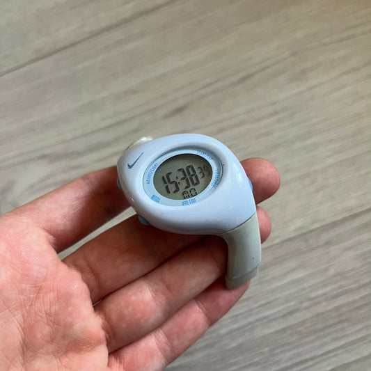 Rare late-1990s Nike Triax Roar J digital watch in a white/milky colorway with blue accents. Features an asymmetrical, ergonomic case and sporty design with a milky rubber band. The strap was broken so it needs fixing, making this either for display or restoration.