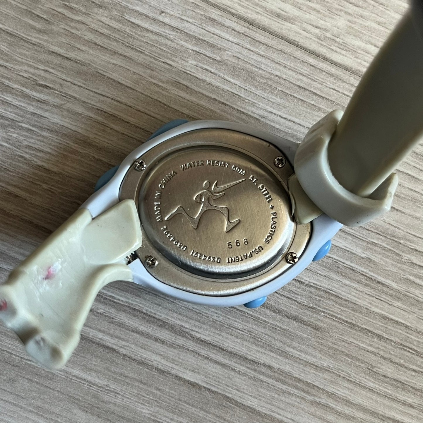 Rare late-1990s Nike Triax Roar J digital watch in a white/milky colorway with blue accents. Features an asymmetrical, ergonomic case and sporty design with a milky rubber band. The strap was broken so it needs fixing, making this either for display or restoration.