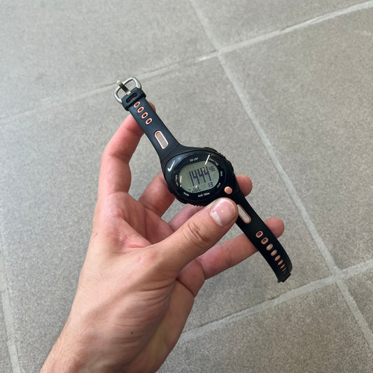 Nike Triax Speed 50 Regular Pink Digital Watch features a black case with four black side buttons and a pink-ish front button for the backlight function. The watch has an white Nike Swoosh on the top of the case, 50-lap memory, multiple modes, and 100m water resistance.