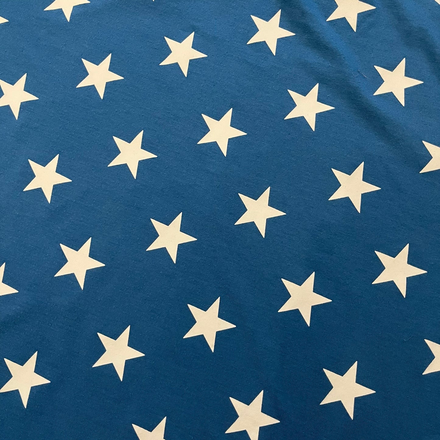 Oakley Crazy Stars Tee in blue with an all-over white star print covering the top two-thirds of the front, back, and sleeves. Features a large Oakley “O” logo on the front. Made from a cotton/polyester blend in El Salvador.