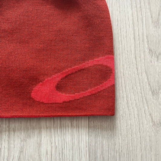 Oakley Side Ellipse beanie in flame red featuring a tilted lighter red O ellipse logo on the side. Reversible design and 100% acrylic construction make it both versatile and cozy. A clean, standout piece for casual and outdoor looks.
