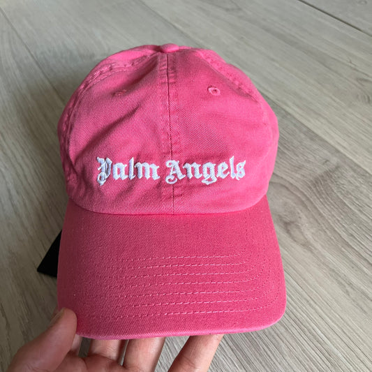 Palm Angels Classic Logo Pink Baseball Cap crafted from 100% cotton. Features white embroidered Palm Angels logos on the front and back in gothic-inspired lettering. A clean, minimal statement piece with a bold color pop.