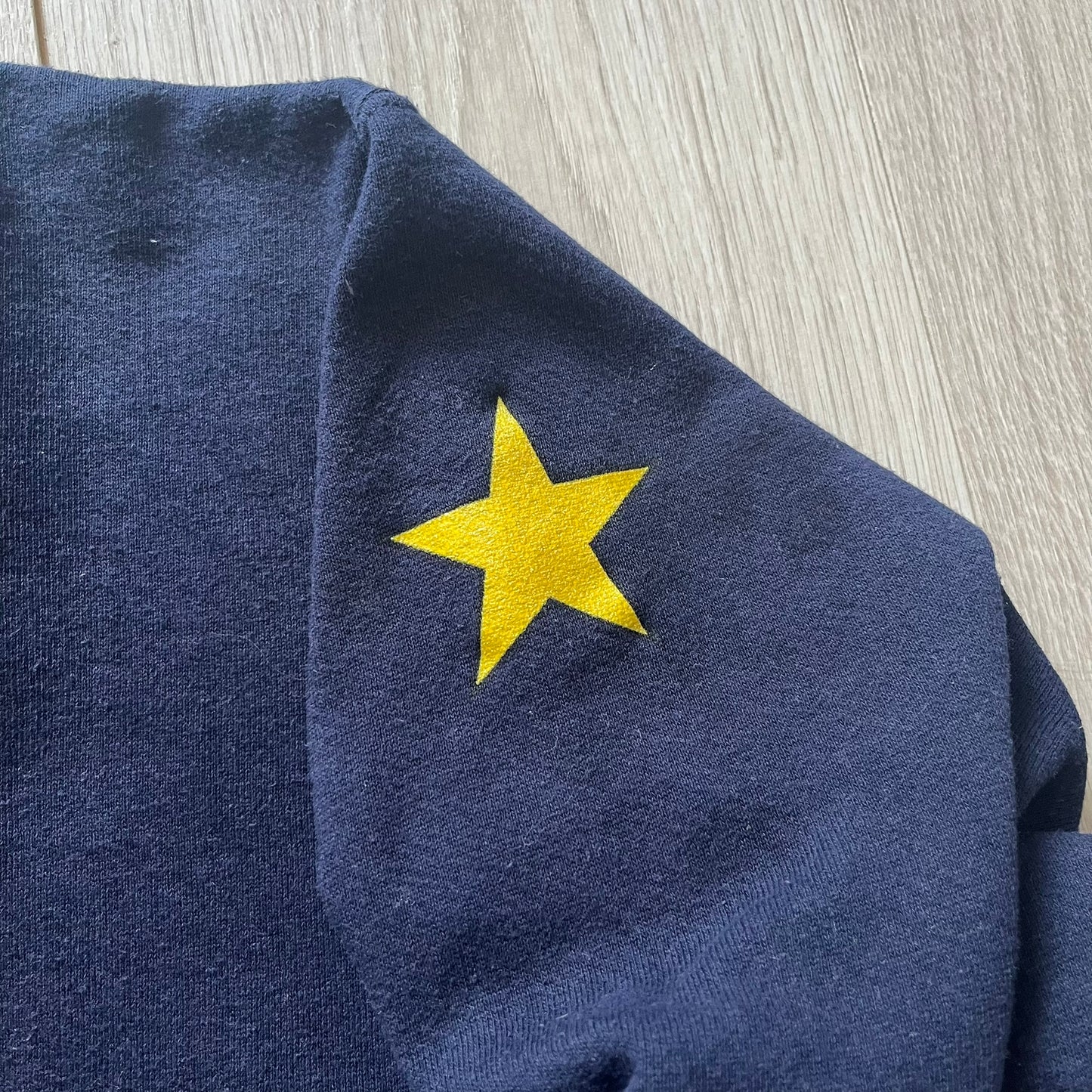 Navy blue fabric with a yellow star on a wooden surface