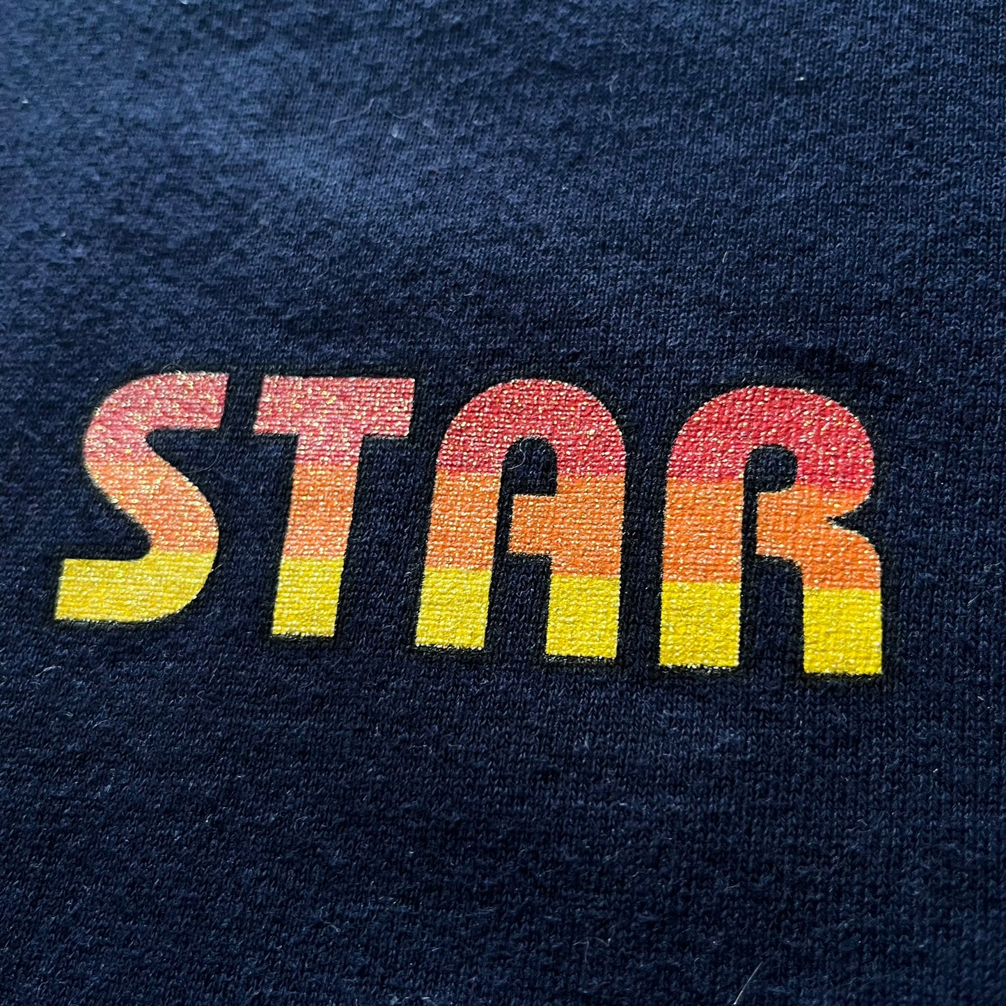 Colorful 'STAR' text on a dark blue fabric background