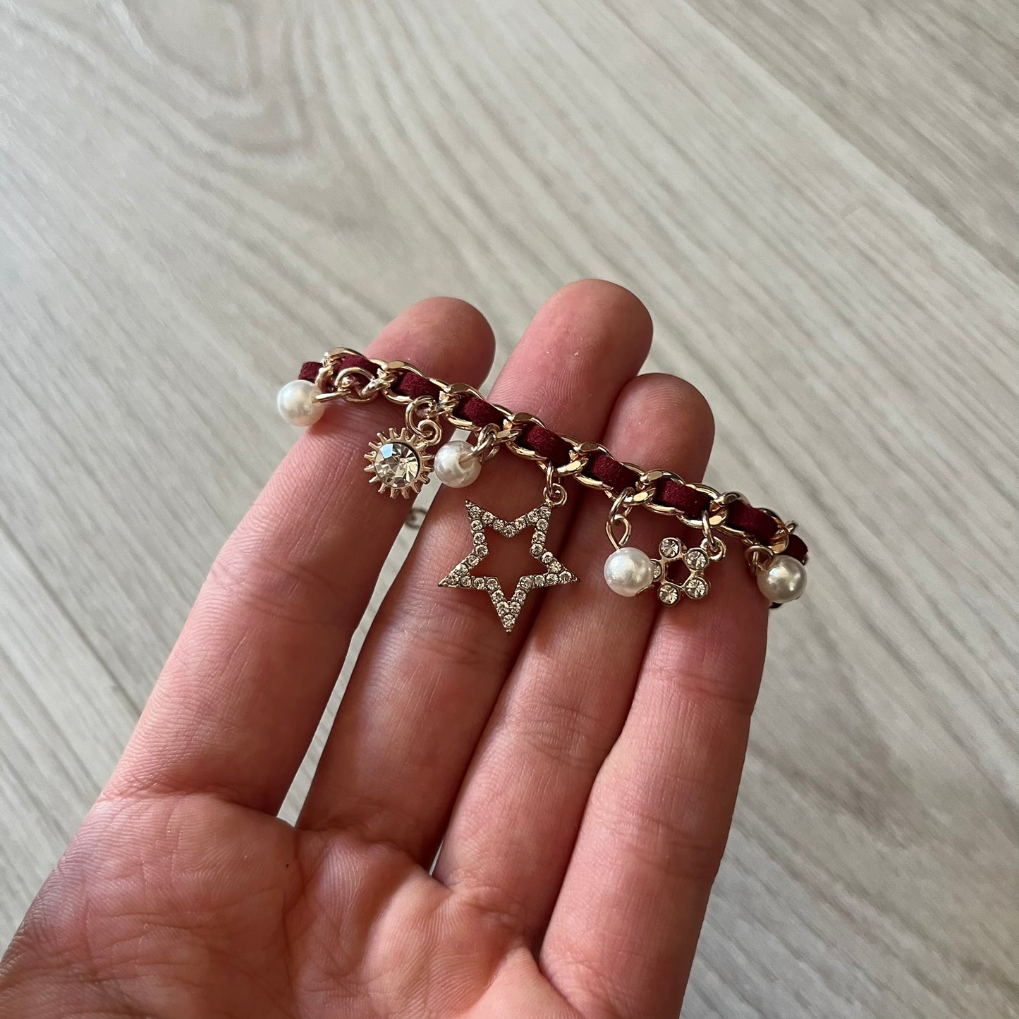 Set of four Rocawear bracelets, each with distinct design elements. Highlights include a “Girl Power” cube bracelet, a burgundy string with gold chain and pearl/zirconia charms, and two simple rose gold bands. Comes presented in a holographic silver box, ideal for collectors or as a stylish accessory set.