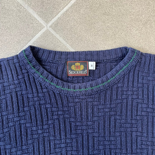 Sedgefield 1990's Basketweave Navy Sweater is a heavyweight navy sweater made in the USA, featuring a thin green line detail on the collar.