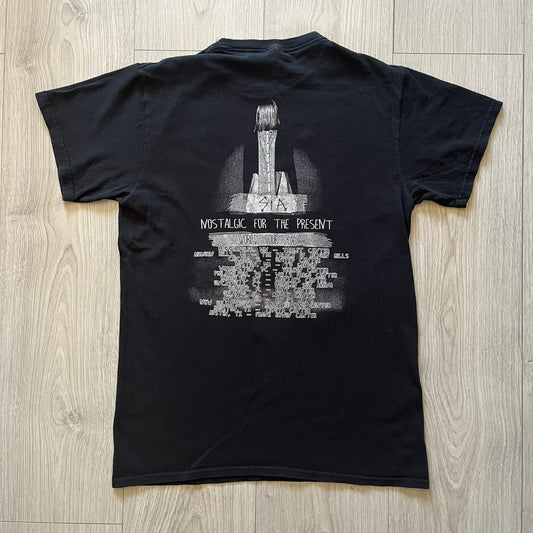 Sia 2016 Nostalgic For The Present tour tee in black, printed on a durable Delta Pro Weight blank. The front features a Sia graphic, while the back lists all U.S. tour cities where she performed. Made as official merchandise for the 2016 tour, this tee combines quality construction with collectible tour details.