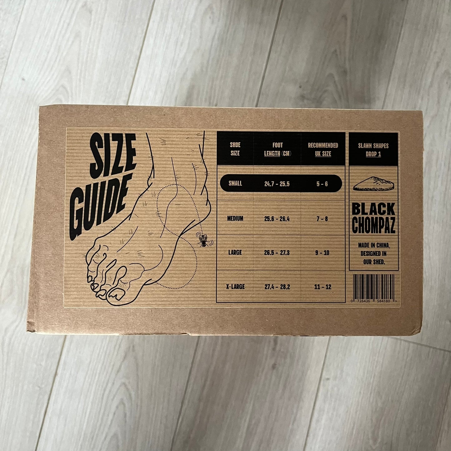 Slawn Shapes Black Chompaz Sliders in the black colorway, designed by artist Olaolu Slawn in collaboration with Shape Shoes. These closed-toe rubber sliders feature Slawn’s signature face design as the body of the shoe. They include a custom tread pattern that leaves a unique footprint. Packaged in a cardboard box with a special plastic bag covered in Slawn’s signature face graphics.