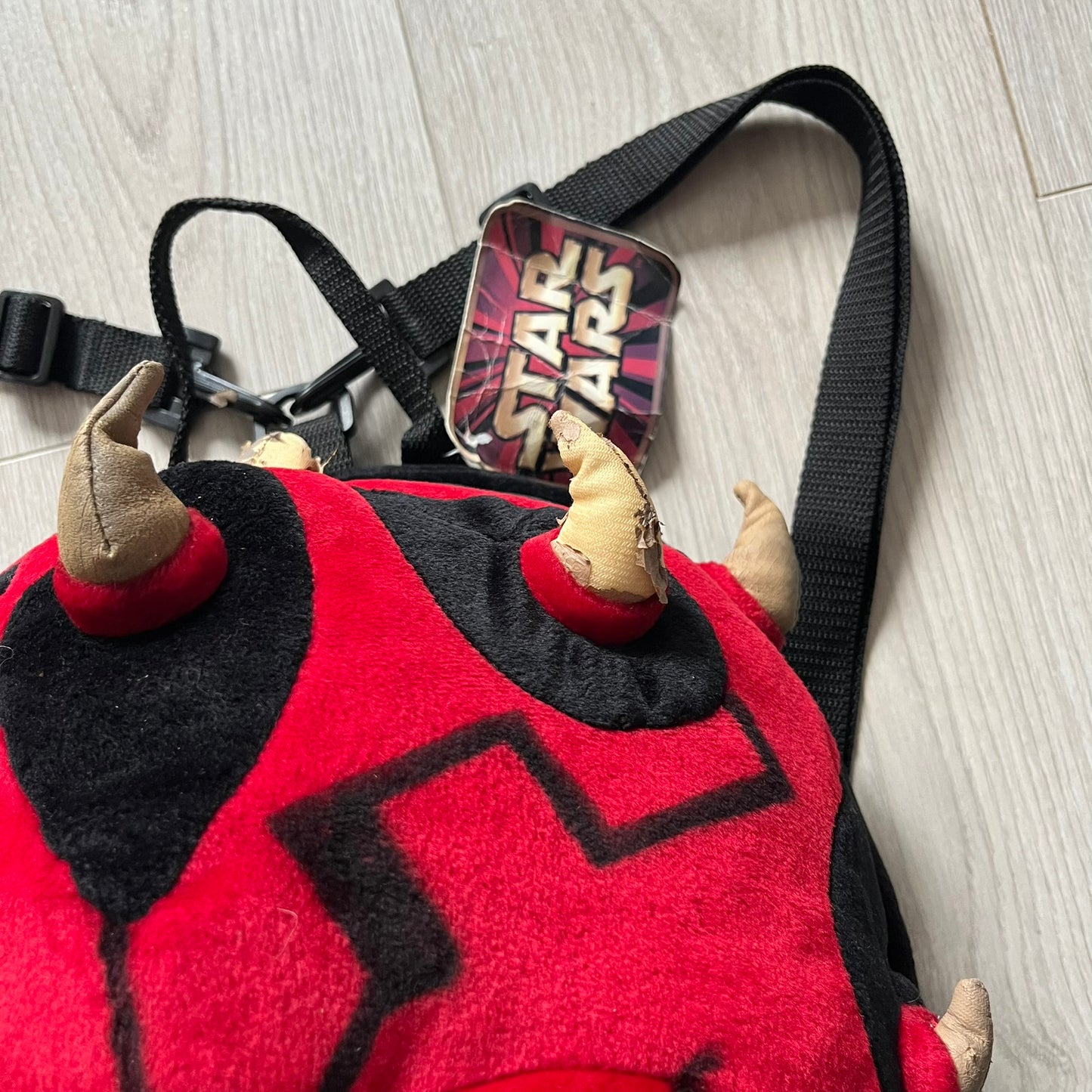 Star Wars 90's Darth Maul Head Backpack - a plush backpack shaped like Darth Maul’s head with striking red-and-black detailing and realistic plastic eyes. Features a small zip compartment on the back and adjustable straps, perfect as a collectible or standout accessory.