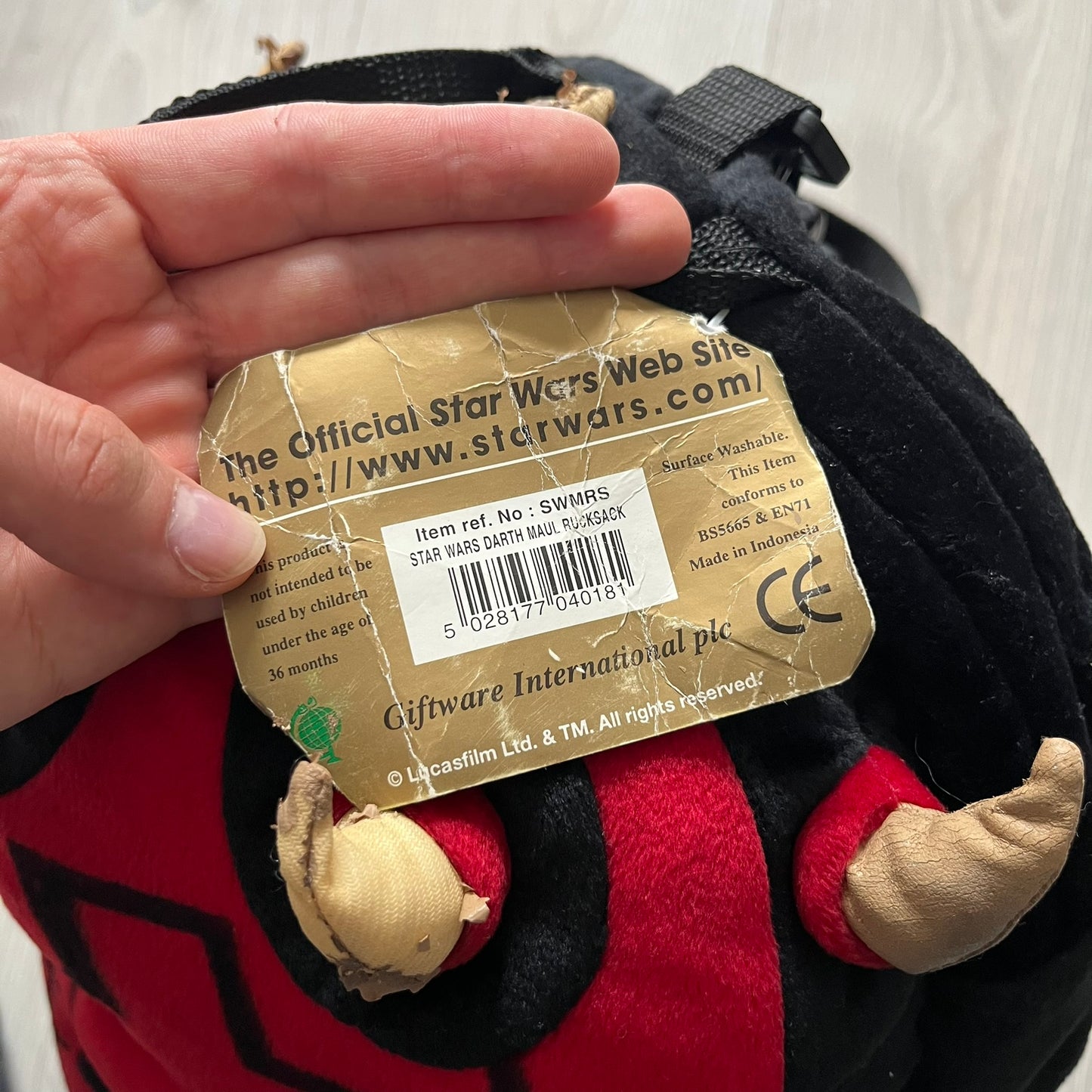 Star Wars 90's Darth Maul Head Backpack - a plush backpack shaped like Darth Maul’s head with striking red-and-black detailing and realistic plastic eyes. Features a small zip compartment on the back and adjustable straps, perfect as a collectible or standout accessory.