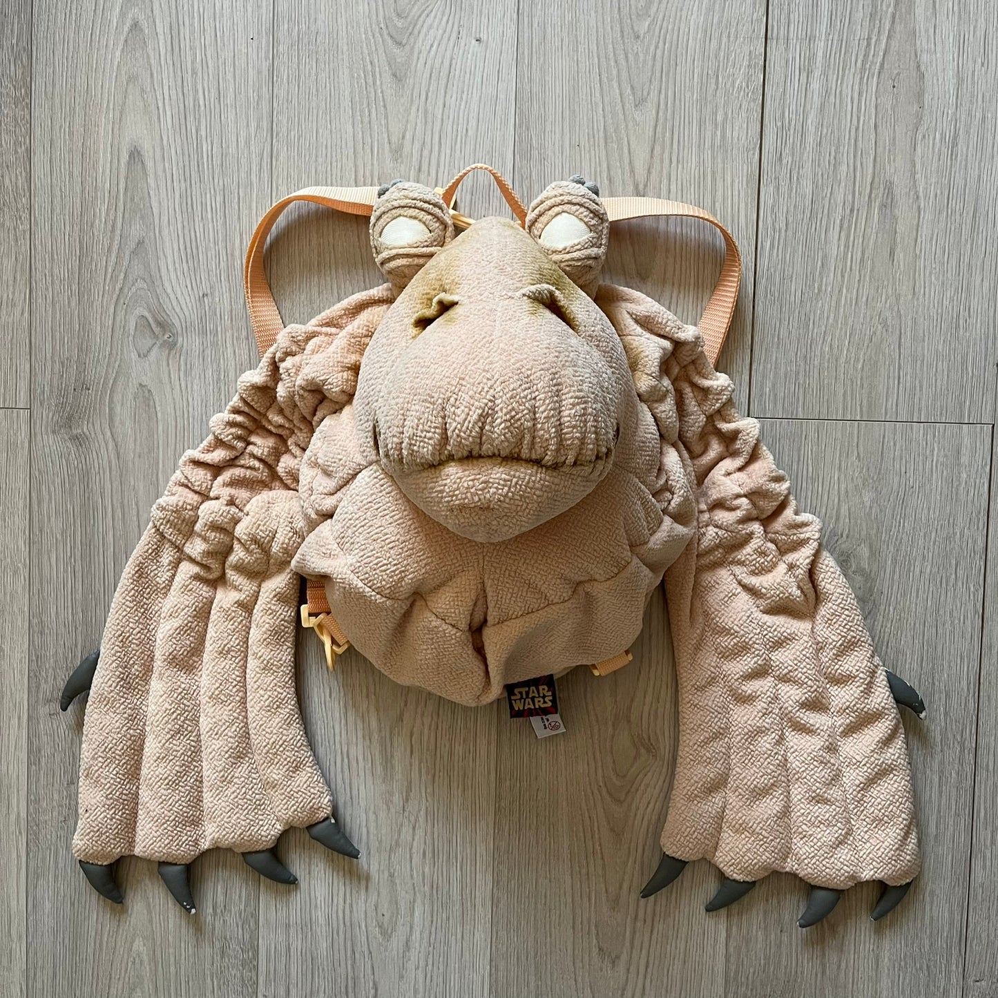 Vintage 1990s Star Wars backpack shaped like Jar Jar Binks’ head, complete with oversized ears for a playful, collectible design. This nostalgic piece captures the quirky charm of the character while offering functional storage. A rare, fun accessory for fans of classic Star Wars memorabilia.