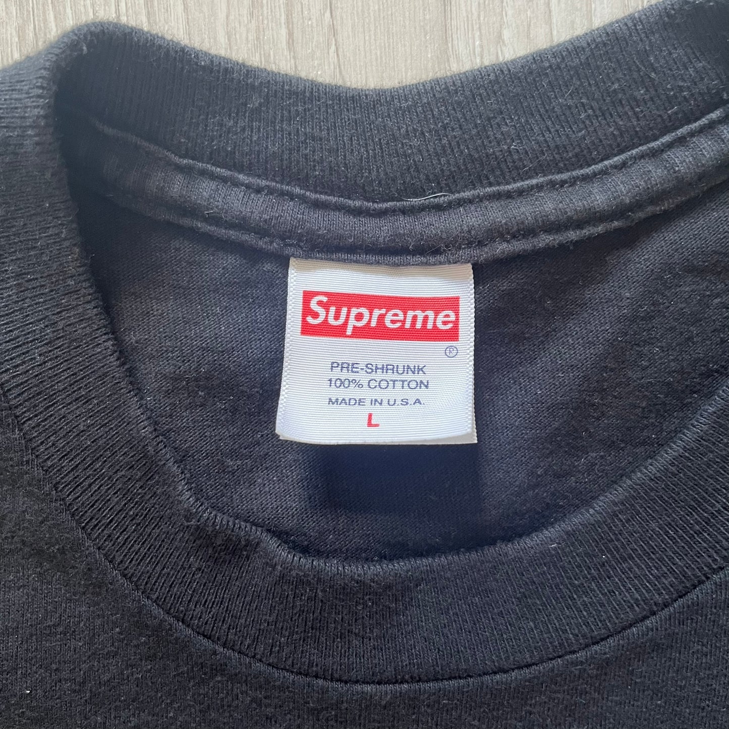 Supreme FW23 “American Psycho” tee in black, released October 2023. Features a large front print of Marshall Arisman’s iconic cover art for Bret Easton Ellis’s novel American Psycho, with big SUPREME text beneath. A standout graphic piece that merges literature, art, and streetwear.