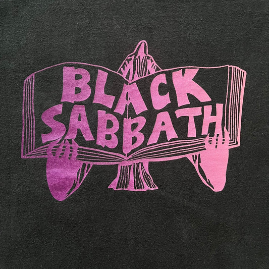From Supreme’s SS16 Black Sabbath collaboration, the Tome Tee arrives in black with striking purple graphics. The front shows the band’s Children of the Grave artwork within a book, contrasted by a gothic Supreme logo on the back. A sought-after item bridging metal iconography and Supreme’s streetwear legacy.