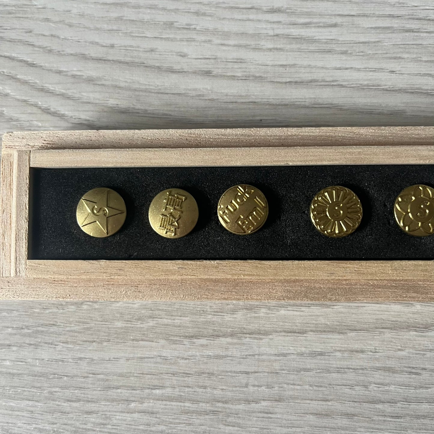 The Supreme CDW Push Pin FW24 Set, released in Week 10 (October 2024), offers eight brass-made pins with detailed debossed graphics including the classic Box Logo and “Fuck Em!” motif. Produced in Japan, this set turns simple desk essentials into collectible Supreme artifacts.