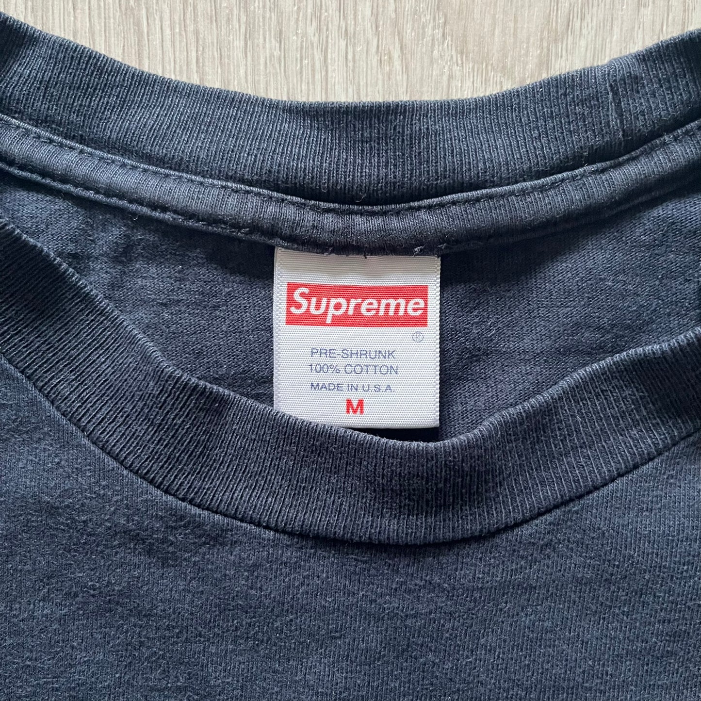 Supreme Clientele FW20 Navy Tee released in October 2020 as part of Supreme’s Fall/Winter 2020 collection. This cotton tee pays tribute to Ghostface Killah’s 2000 album Supreme Clientele, featuring the album’s iconic title graphic on the front and full tracklist on the back. A standout Supreme graphic tee that merges streetwear with hip-hop history.