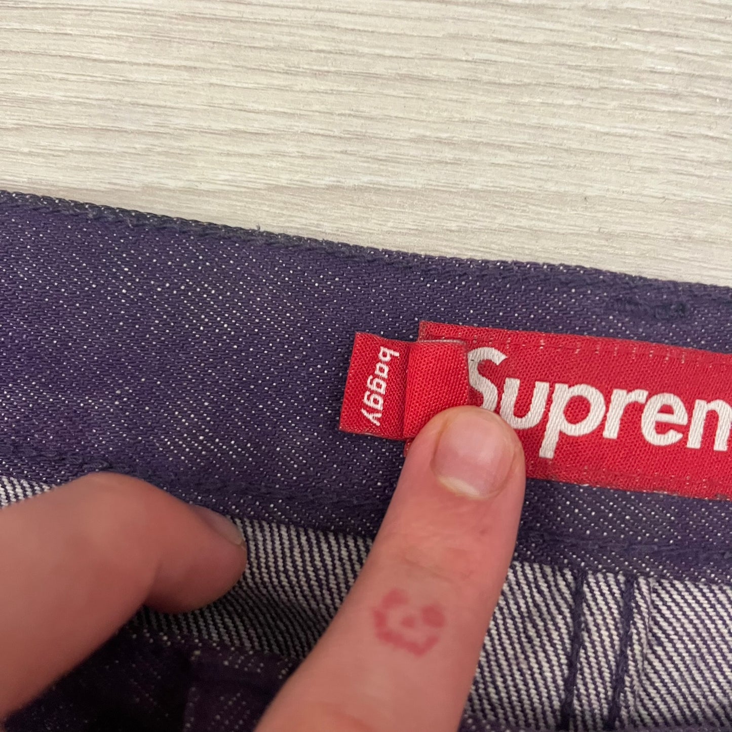 Supreme Denim Purple SS25 Baggy Shorts crafted from 13 oz. all-cotton denim in a purple hue. Features a relaxed baggy fit, classic five-pocket styling, zip fly, copper oxide rivets, and embroidered Supreme New York logo on the back pocket. Durable, stylish, and perfect for everyday streetwear.