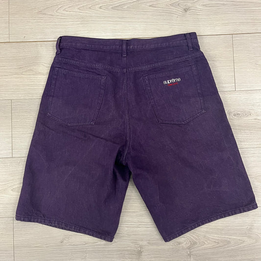 Supreme Denim Purple SS25 Baggy Shorts crafted from 13 oz. all-cotton denim in a purple hue. Features a relaxed baggy fit, classic five-pocket styling, zip fly, copper oxide rivets, and embroidered Supreme New York logo on the back pocket. Durable, stylish, and perfect for everyday streetwear.