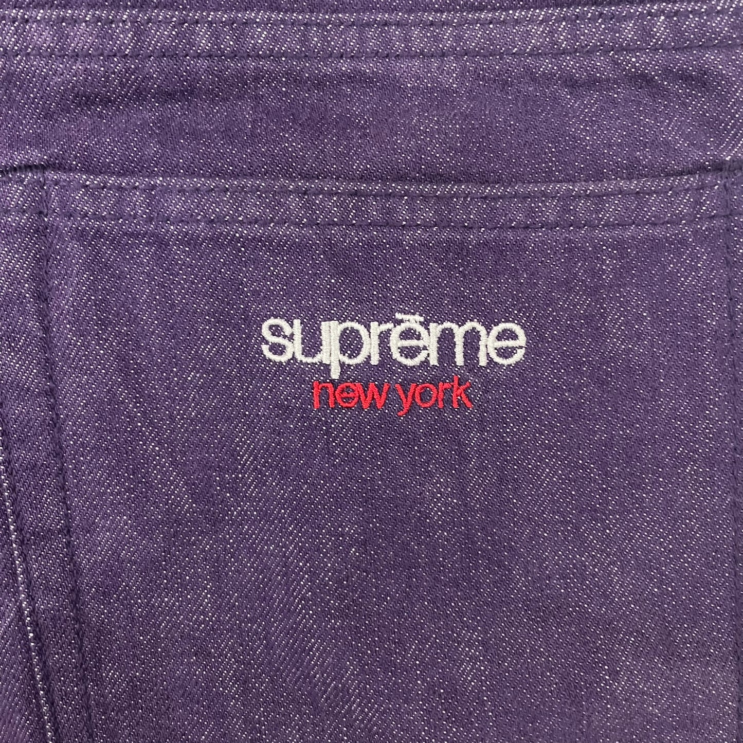 Supreme Denim Purple SS25 Baggy Shorts crafted from 13 oz. all-cotton denim in a purple hue. Features a relaxed baggy fit, classic five-pocket styling, zip fly, copper oxide rivets, and embroidered Supreme New York logo on the back pocket. Durable, stylish, and perfect for everyday streetwear.