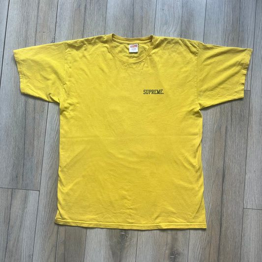 Supreme FW12 Stax Records Tee is a yellow T-shirt from the Fall/Winter 2012 collection. The front features small black Supreme text on the left chest. The back has a large Stax Records logo print with the blue and white hand graphic and red Stax text underneath. Concord Music Group licensing on the necktag.