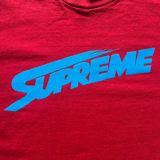 Supreme Mont Blanc Red Tee from the FW23 collection, released on October 5th, 2023 (Week 7). Made from 100% cotton, this red tee features a bold blue Supreme logo printed across the chest, with a clean monochrome back. A classic Supreme piece with a simple yet striking color contrast and casual silhouette.