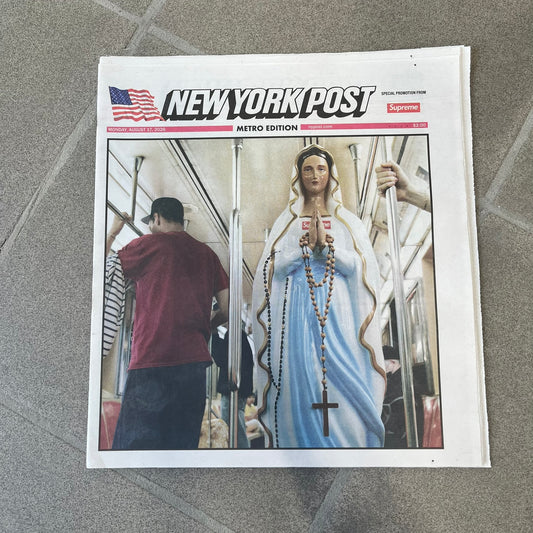 Supreme New York Post Newspaper “Late City Final Edition” from Fall/Winter 2026, released on August 17th, 2026. Features the features a religious statue with iconic Supreme box logo printed on it. On the back there's a "Deliver US From Evil". Includes the full original newspaper, with only the cover designed by Supreme.