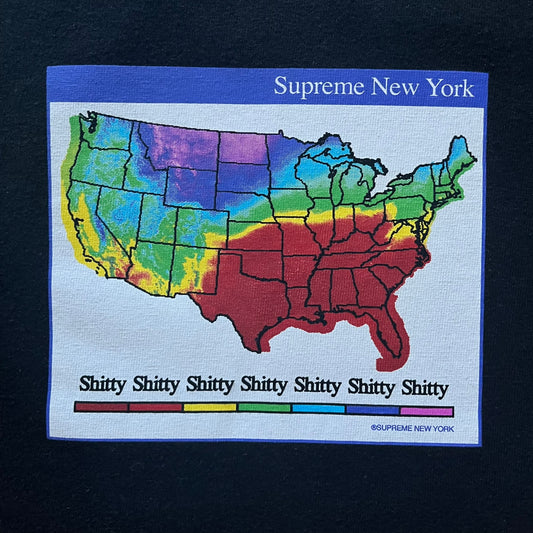 Supreme “Weather” FW23 tee in black, showcasing a satirical weather map graphic of the USA. Below sits a gradient bar in red-to-pink tones, with every category marked “Shitty.” Includes small Supreme New York text detail, true to the collection.