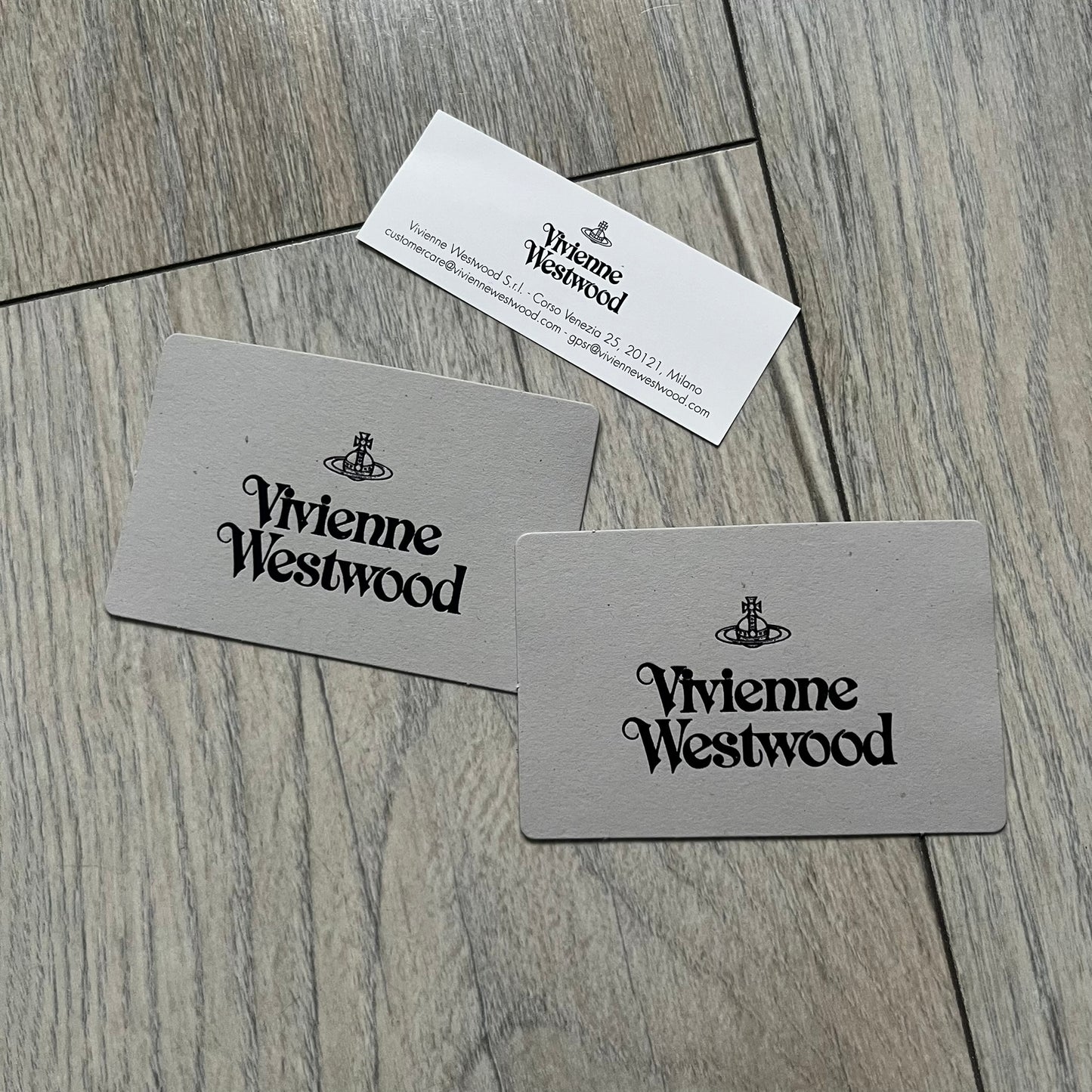 Vivienne Westwood Brown Flat Card Holder is crafted from buffed leather in a camel brown tone with logo hardware at the front. It features four card slots, a central note compartment, black twill lining, and an interior leather Vivienne Westwood tab with a material tag. Made in Italy, the card holder comes with the original box and tags. 252314M163098