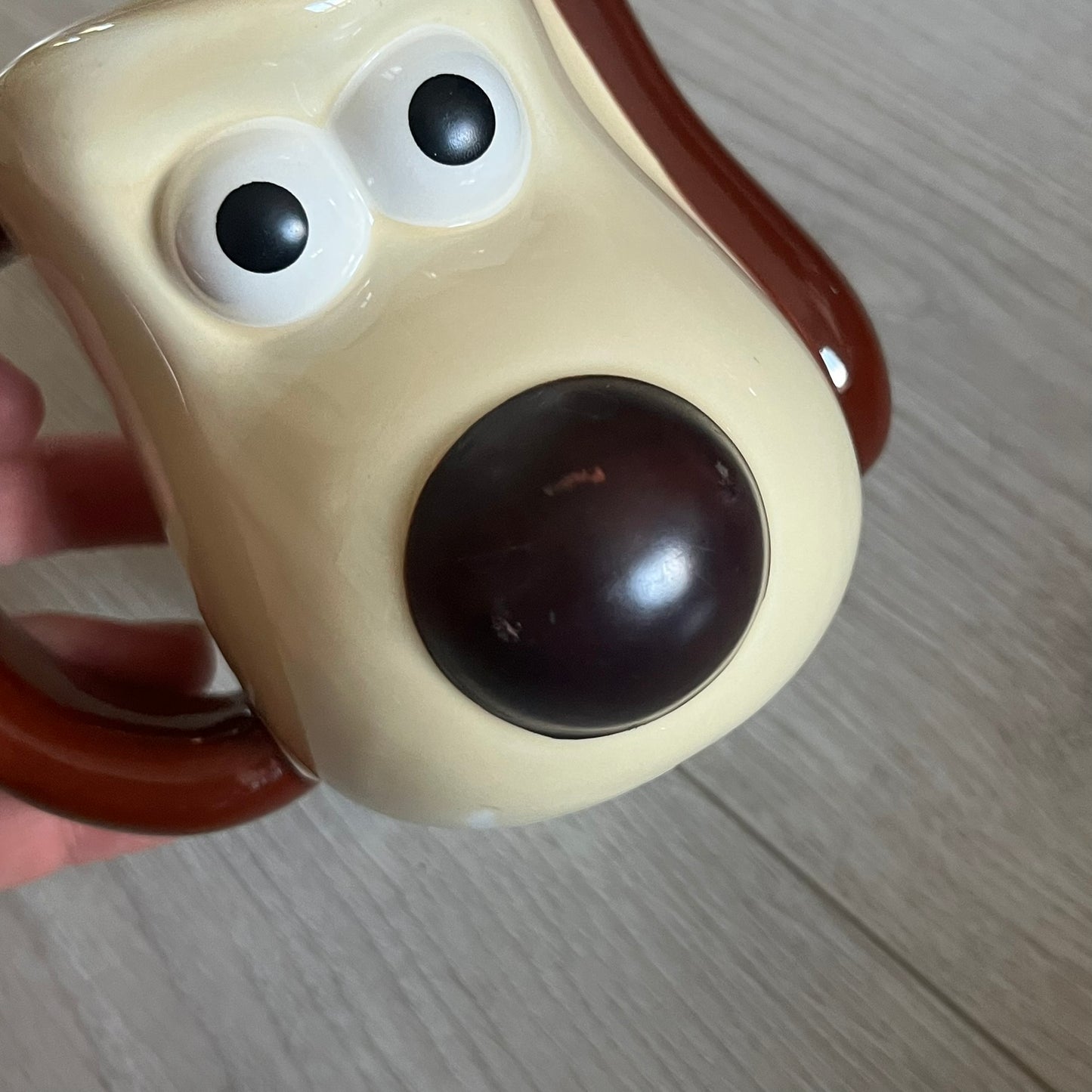This 2005 Wallace & Gromit ceramic mug captures the beloved character in full 3D detail, with protruding eyes and nose and an irregular sculpted form. One ear doubles as the handle, adding playful functionality to the design. Created exclusively for PG Tips, it’s finished with official licensing and copyright on the base.