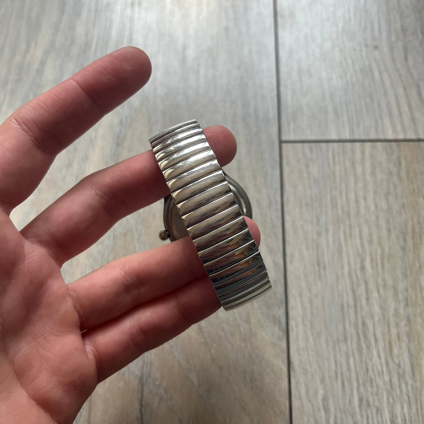 Warner Bros Marvin the Martian 1996 Analog Watch is a stainless steel watch with a shiny finish and a stretch expansion bracelet made from connected metal links. The dial is metallic and reflective with blue numerals and a graphic of Marvin the Martian standing with his name printed beside him. The caseback includes Warner Bros 1996 licensing.