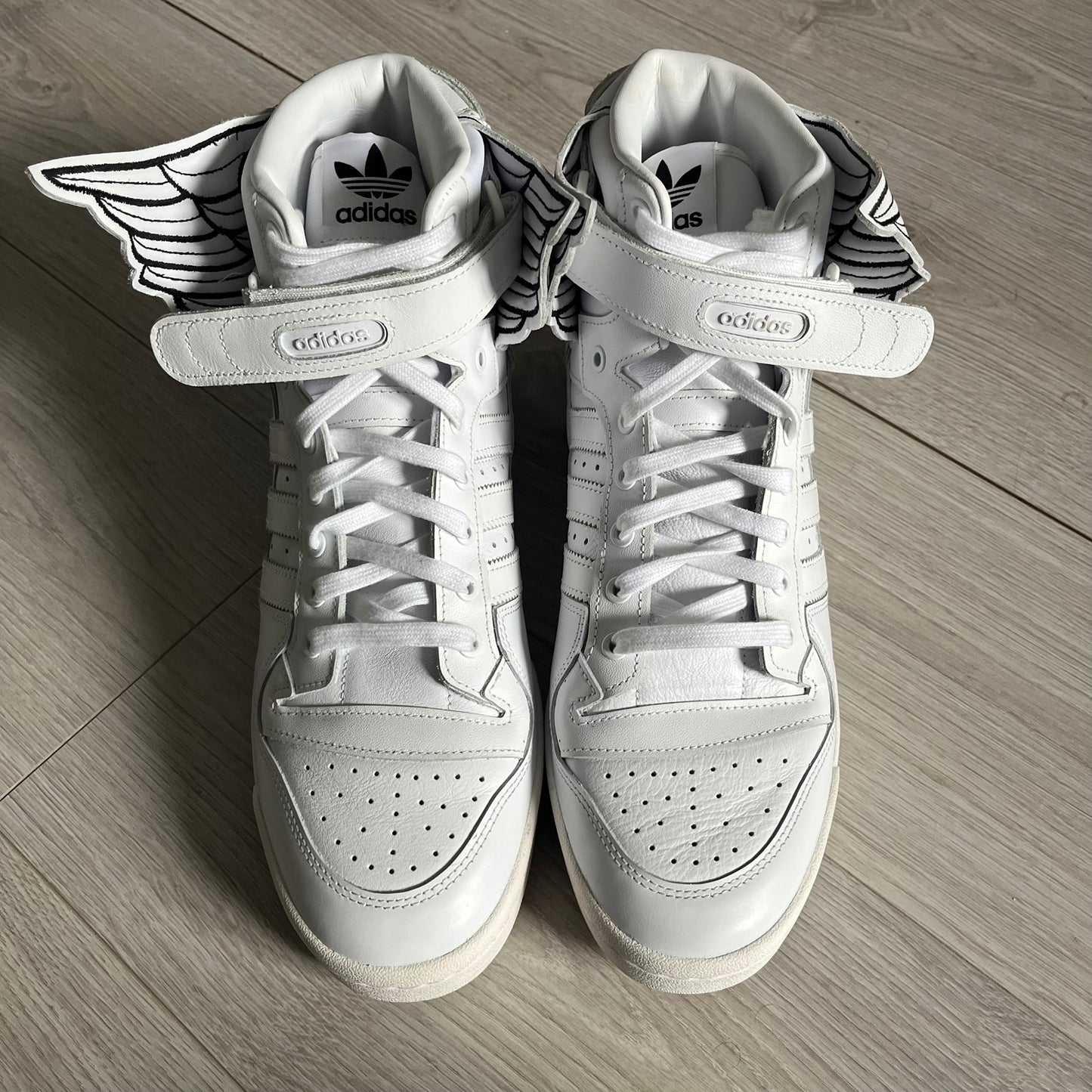 The Adidas Jeremy Scott Wings 4.0 Forum Hi launched on May 5, 2022, in a white and black colorway. Premium leather uppers highlight black stripes, heel tab, and Wings branding, while the high-top structure provides support with a padded collar and tongue. Equipped with a rubber herringbone outsole for grip, this limited edition release merges classic silhouette with JS design.