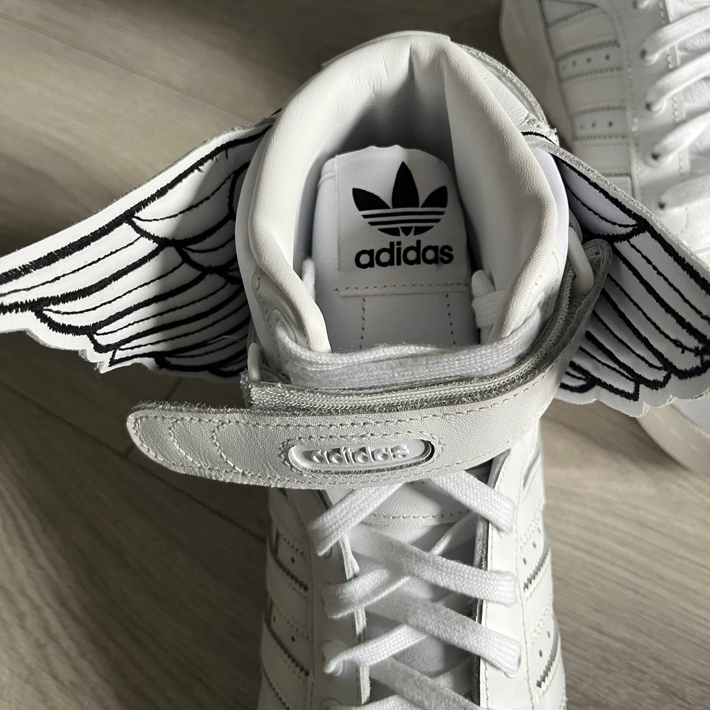 The Adidas Jeremy Scott Wings 4.0 Forum Hi launched on May 5, 2022, in a white and black colorway. Premium leather uppers highlight black stripes, heel tab, and Wings branding, while the high-top structure provides support with a padded collar and tongue. Equipped with a rubber herringbone outsole for grip, this limited edition release merges classic silhouette with JS design.
