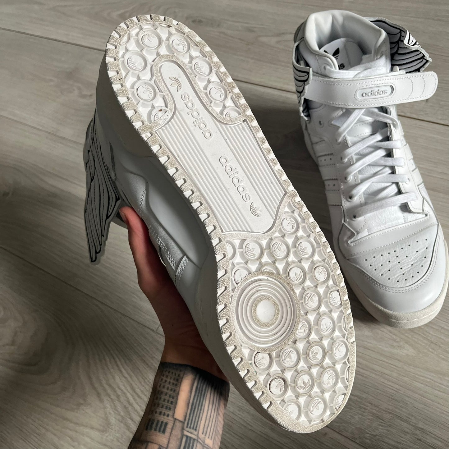 The Adidas Jeremy Scott Wings 4.0 Forum Hi launched on May 5, 2022, in a white and black colorway. Premium leather uppers highlight black stripes, heel tab, and Wings branding, while the high-top structure provides support with a padded collar and tongue. Equipped with a rubber herringbone outsole for grip, this limited edition release merges classic silhouette with JS design.