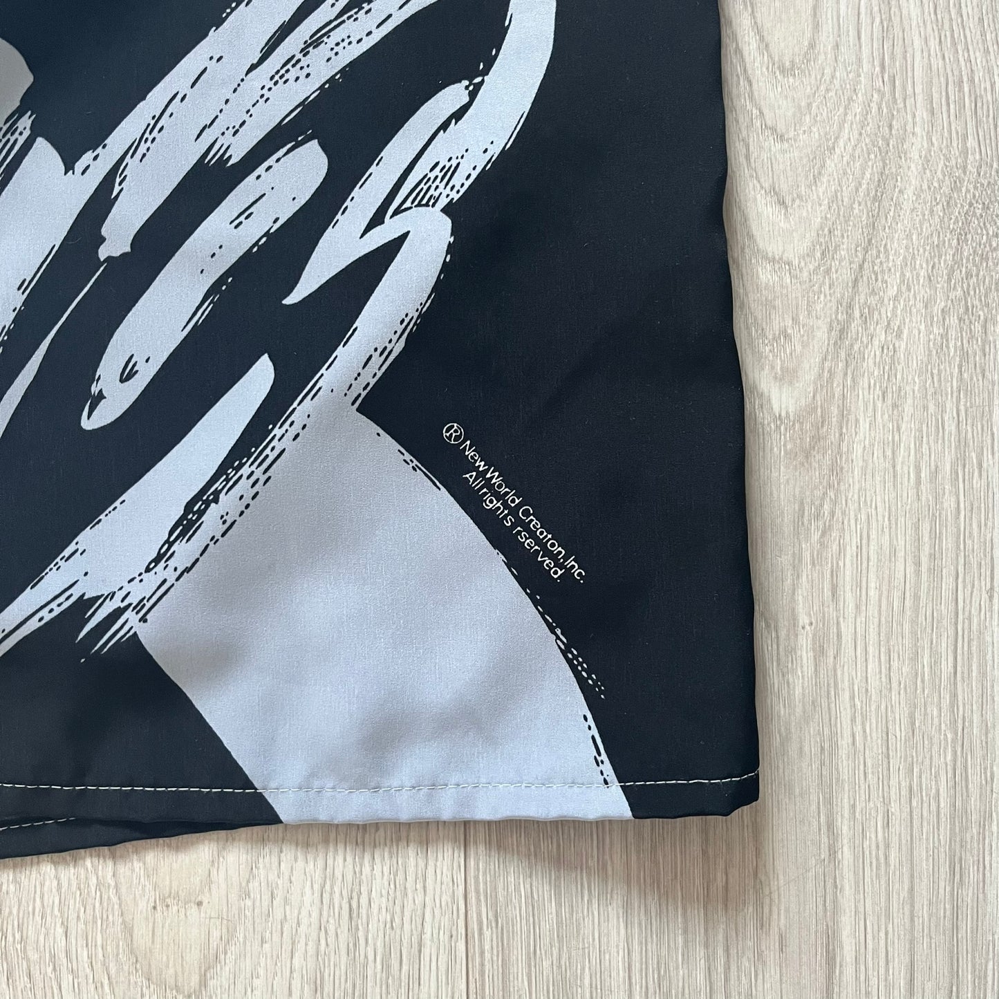 Black shorts with white abstract design on a wooden surface